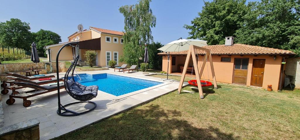 罗波里卡Sunny Garden Villa with Pool的后院设有带秋千和房屋的游泳池