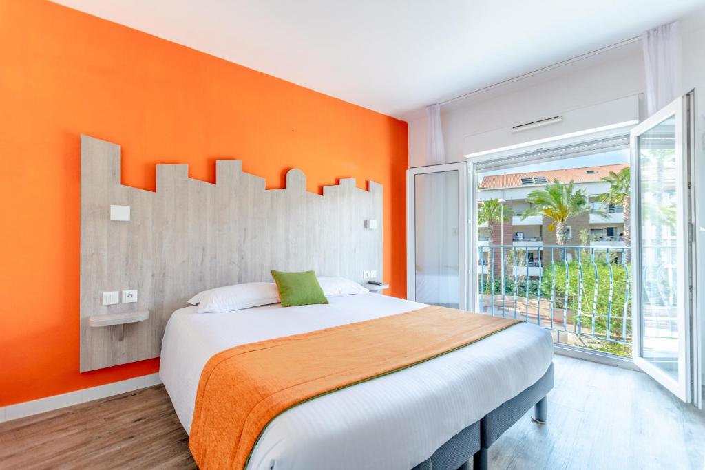 圣拉斐尔普罗文卡尔酒店的一间卧室配有一张带橙色墙壁的大床