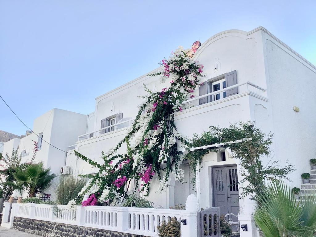 卡马利Villa Maina的一座白色的建筑,花朵花朵