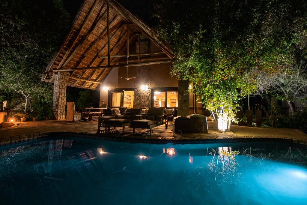 侯斯普瑞特Leopard's Lair Bush Lodge的夜间带游泳池的度假村