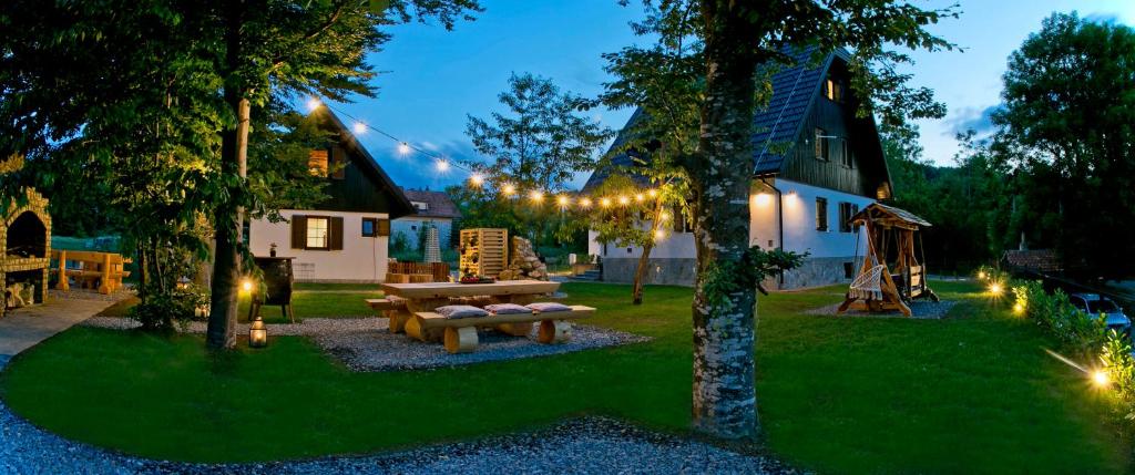 普利特维采湖B&B Plitvice Holiday Lodge的后院设有野餐桌和弦灯