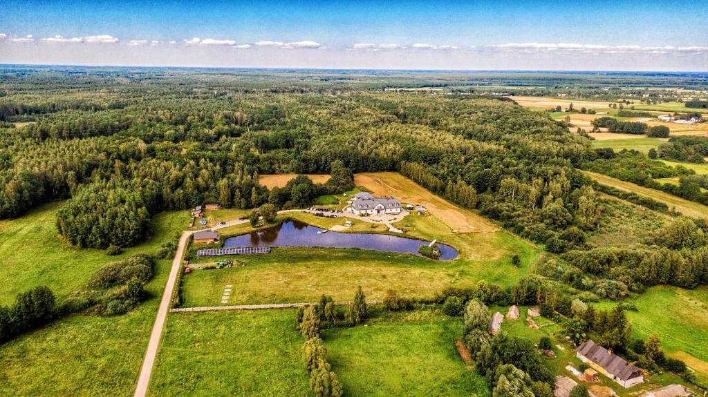 Majdan StulenskiDwór Nad Bugiem的享有湖泊和树木庄园的空中景致