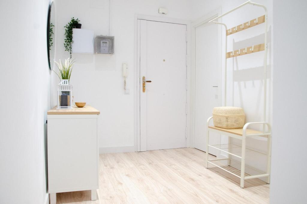 巴塞罗那Apartamento NUEVO con encanto en SAGRADA FAMILIA的白色的走廊,设有白色的门和椅子