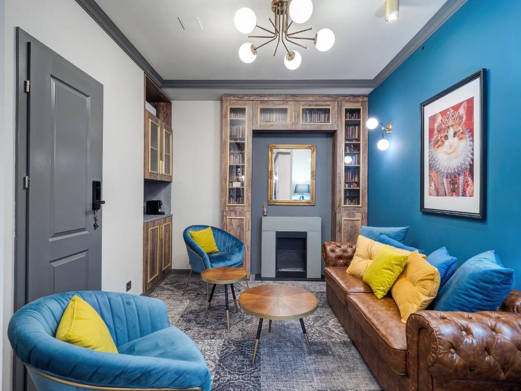 布达佩斯A22 Boutique Suites的客厅拥有蓝色的墙壁,配有沙发和椅子