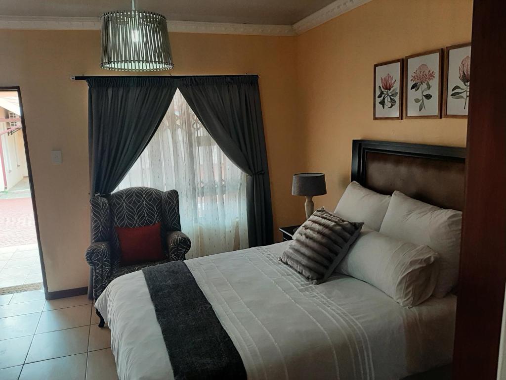比勒陀利亚Lesedi Self Catering的卧室配有床、椅子和窗户。