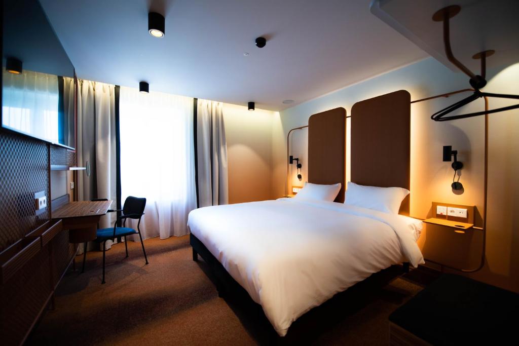 多维尔YOU Are Deauville的酒店客房设有一张大床和一张书桌。