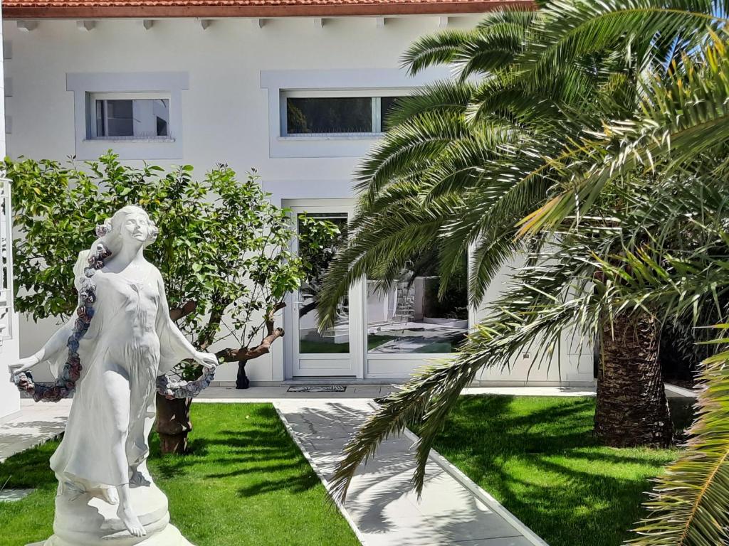 圣雷莫Palms Luxury Suites Sanremo的女方在房子前的雕像