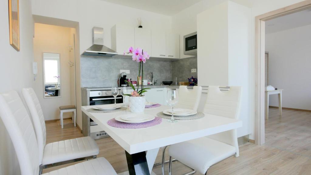 兹诺伊莫Soukromý - plně vybavený byt 2+KK的白色的厨房配有白色的桌子和白色的椅子