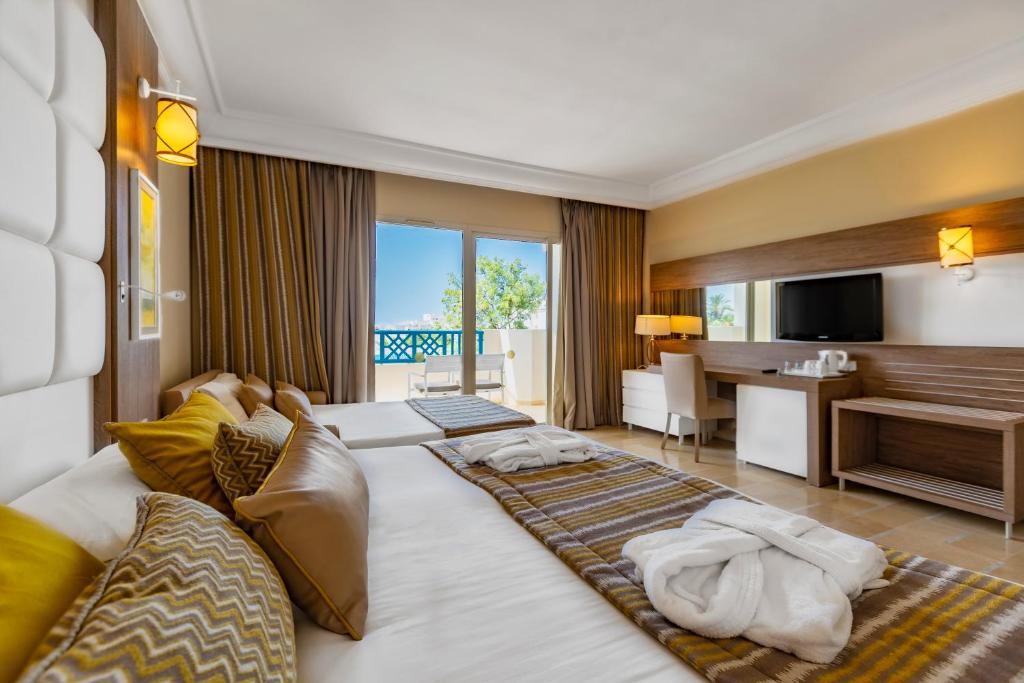 甘达坞伊港Sentido Bellevue Park的酒店客房配有两张床和一张书桌