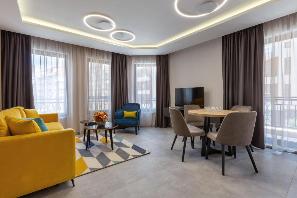 帕莫瑞Inter Holiday Apartments的客厅配有黄色的沙发和桌子
