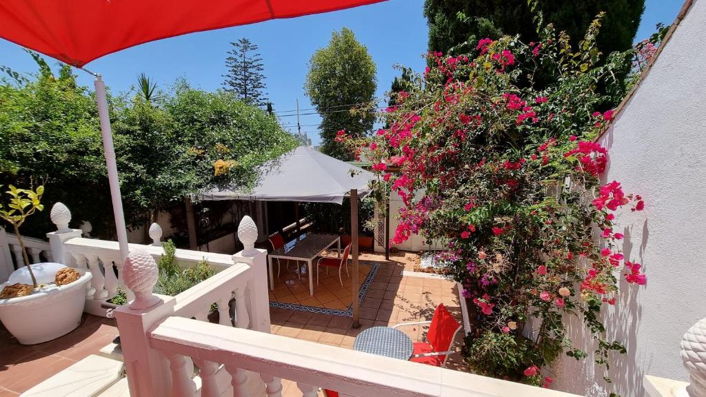 贝纳尔马德纳Roberto Guest House的阳台拥有粉红色的鲜花和白色的围栏