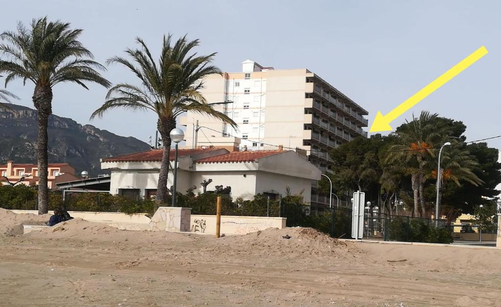 霍斯皮塔勒·德尔英福Apartamento con vistas, entre mar y montaña的建筑前的一座建筑和棕榈树