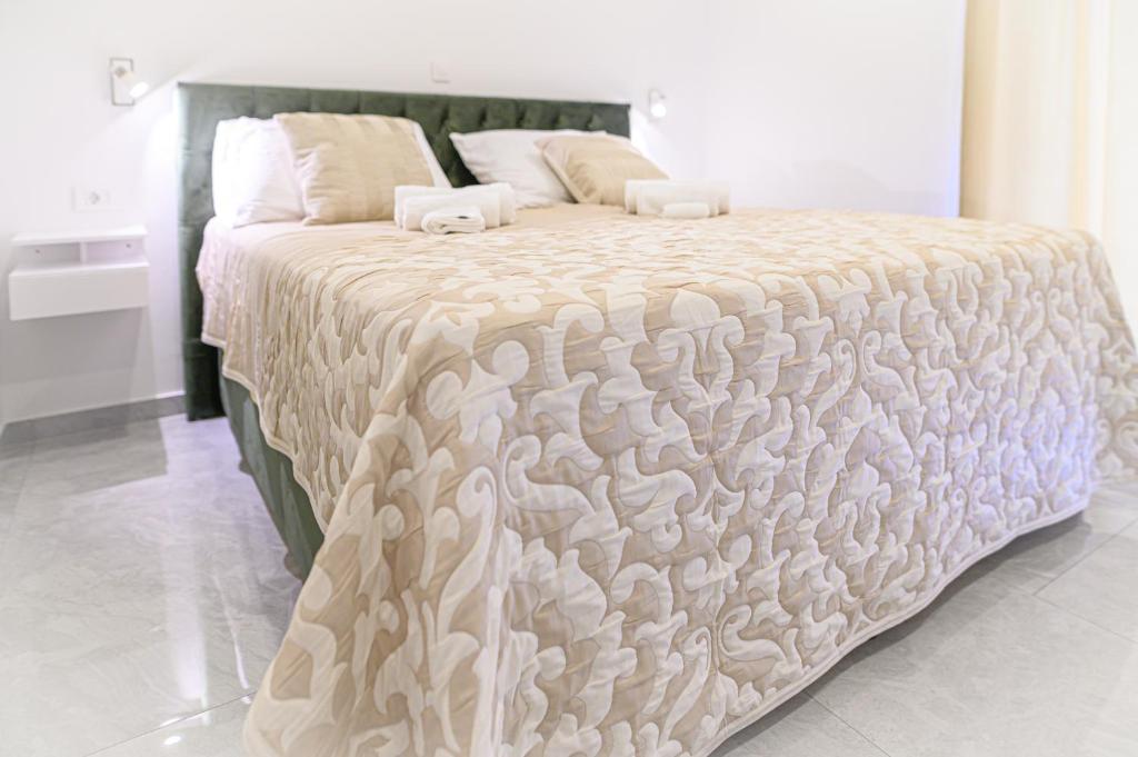 斯普利特Luxury rooms Green and Gold Split的一张带白色棉被和枕头的大床