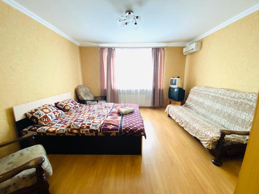 阿尔马维尔City Apartment Sverdlova 71的一间卧室配有一张床、一张沙发和一个窗口