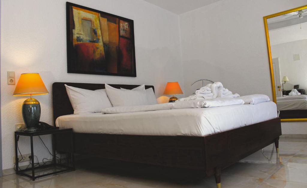 汉诺威Aalto Hotel的一间卧室配有一张带白色床单和两盏灯的床。