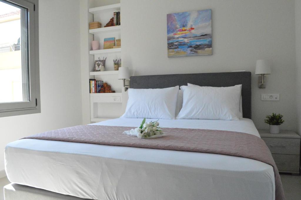 干尼亚Leonidas House的一间卧室配有一张白色大床,床上有鲜花