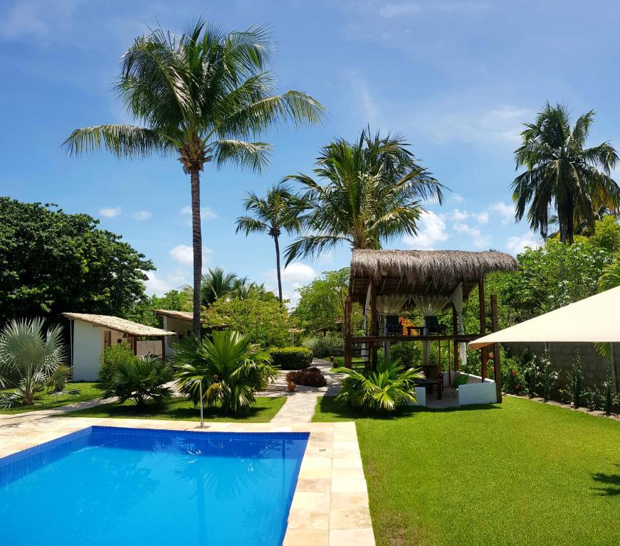 佩德拉斯港Pousada Villages Boutique Hotel - 150m da Praia da Laje的一座别墅,设有游泳池和棕榈树