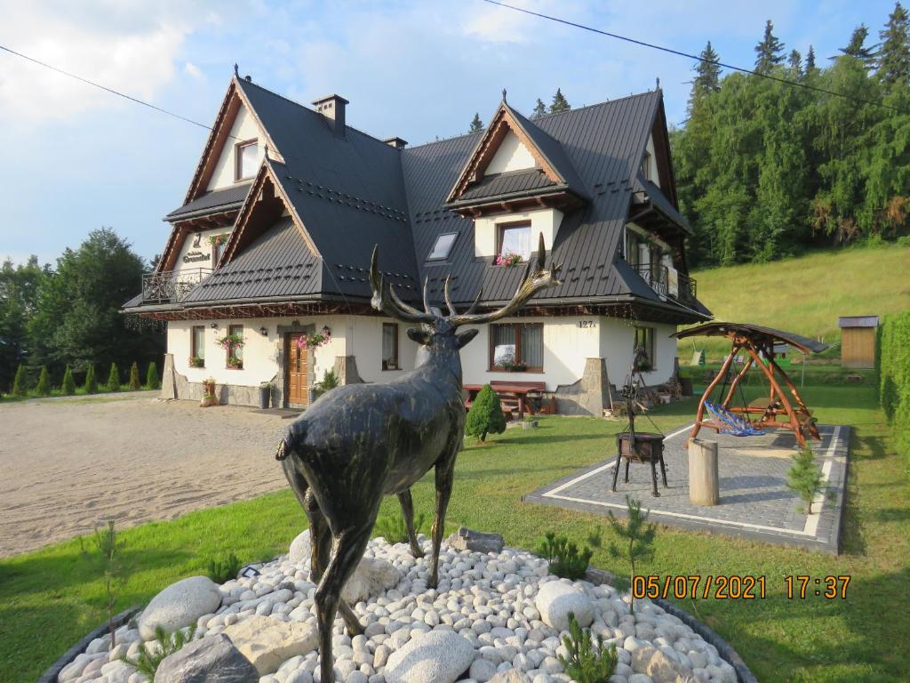 布科维纳-塔钱斯卡Gościniec Grandel domek z balią的鹿在房子前的雕像
