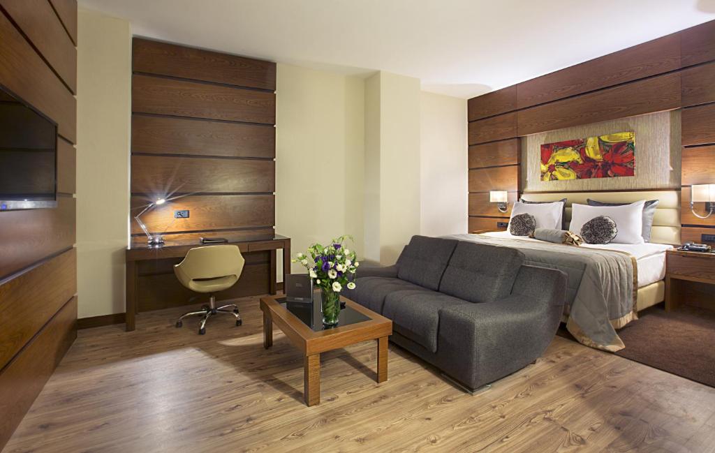 埃尔比勒埃尔比勒市中心德德曼酒店的酒店客房,配有床和沙发