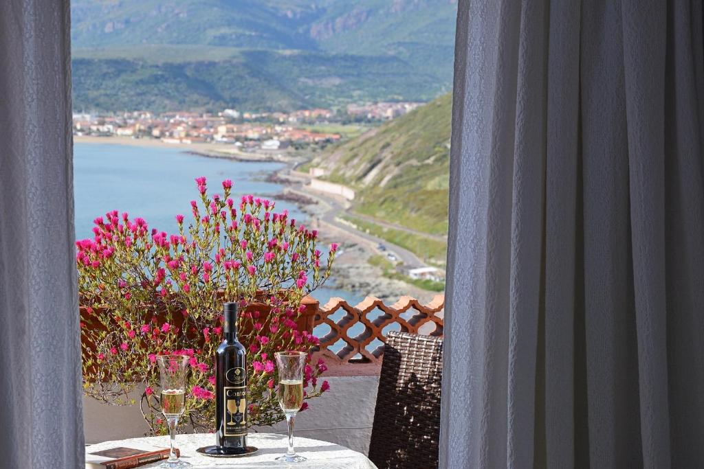 博萨萨鲁梅内拉酒店的阳台上的桌子上摆放着酒杯和鲜花