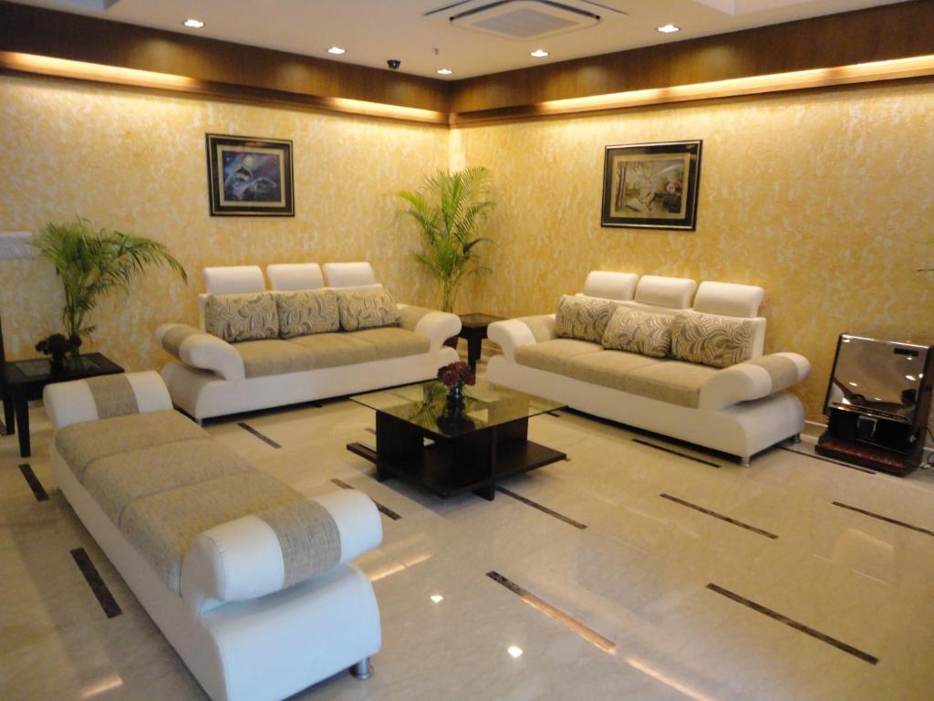 新德里Divine Paradise Tavisha的客厅配有两张沙发和一台电视机