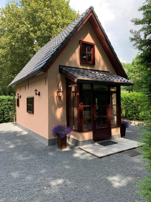 卢特伦Romantisch Gastenverblijf 'Het Vogelhuisje'的车道上有一扇大门的小房子