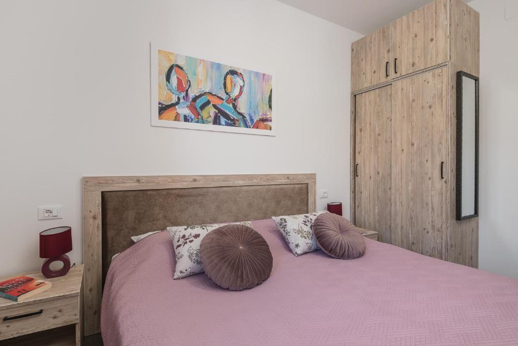 MočićiSky Airport Apartments的卧室配有粉红色的床和2个枕头