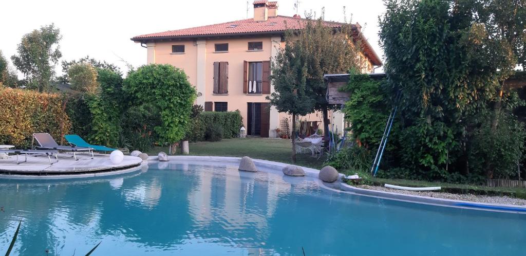 San Giorgio di Piano托里切拉住宿加早餐旅馆的房屋前的大型游泳池