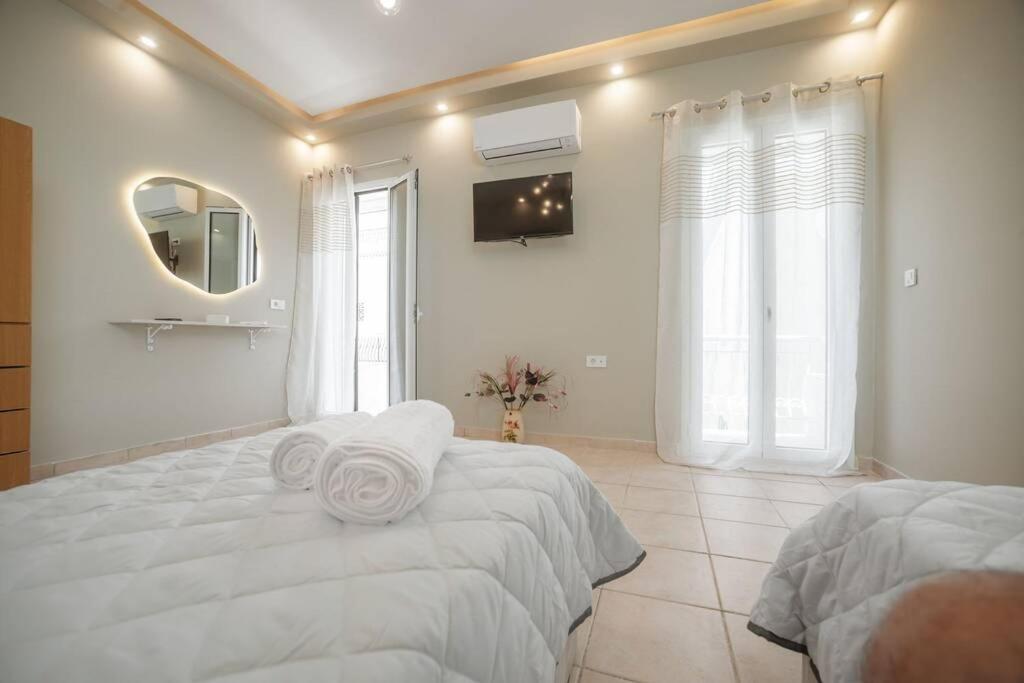 扎金索斯镇El Sueño de Zante 2nd City Center Apartments的白色卧室设有一张大床和镜子