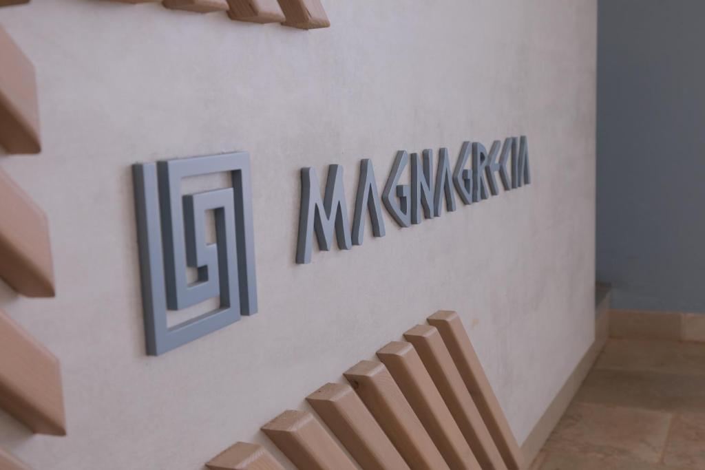 莱乌卡Hotel Magna Grecia的墙上有标志的楼梯
