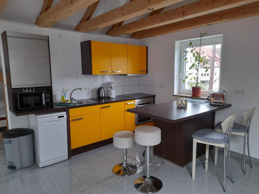 StadtsteinachHaus Lehenthaler的厨房配有黄色橱柜和桌椅