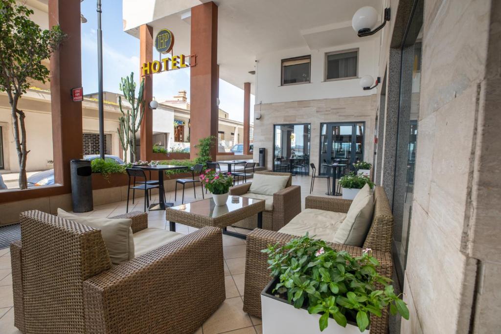 奥尔比亚狄帕兰酒店的餐厅内带藤椅和桌子的庭院