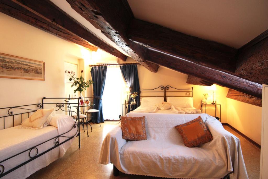 威尼斯卡瑞奇欧酒店的一间卧室设有两张床和窗户。