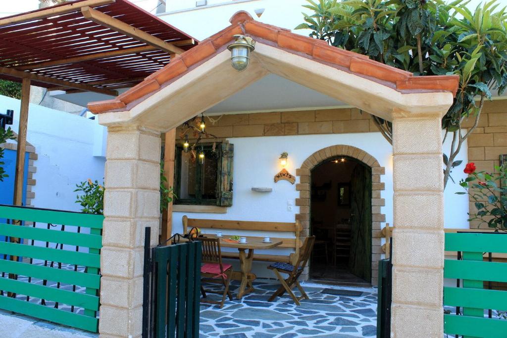 DhrapaniásVillage Villa Marika - Mimis Drapanias的户外庭院设有桌子和遮阳篷