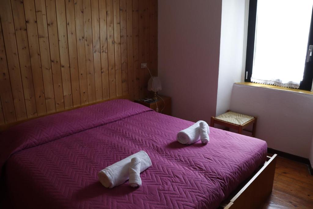 科马诺泰梅B&B Amico的一间卧室配有一张紫色床和毛巾