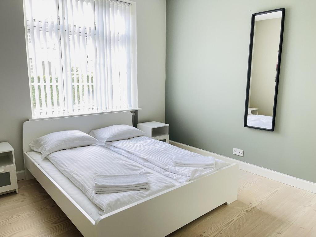 奥尔堡aday - 2 bedroom apartment with Patio的白色卧室内的一张白色床,配有镜子