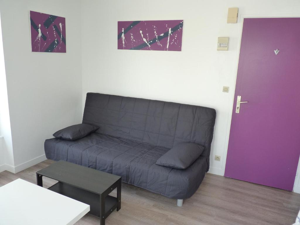 布雷斯特阿尔伯特普利米尔公寓的客厅内的一张沙发,带紫色门