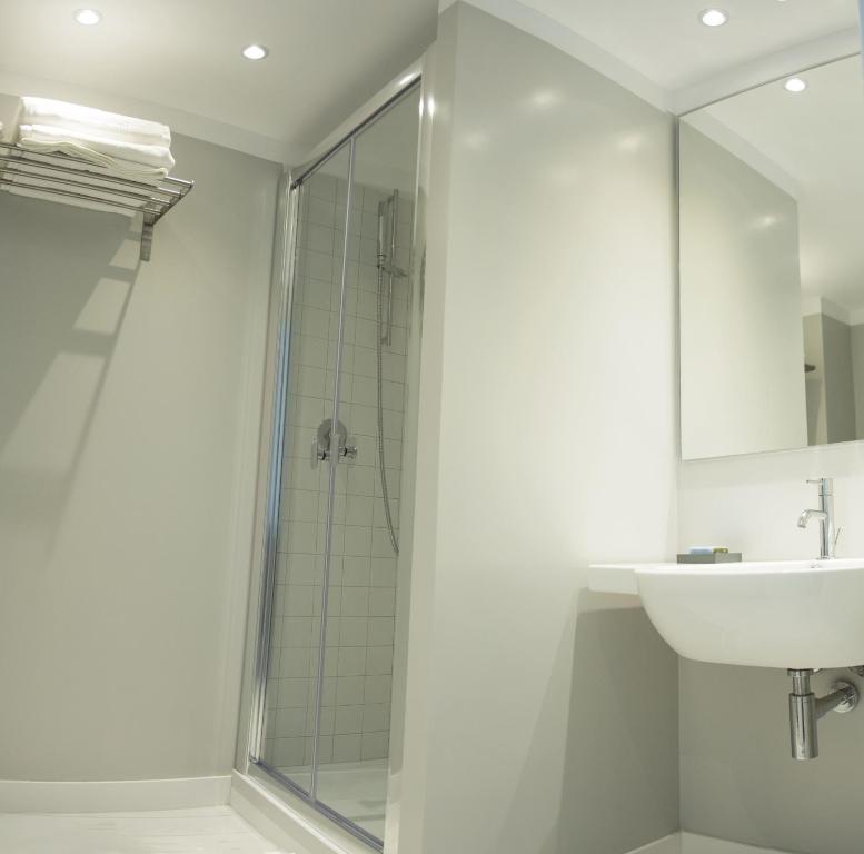卡利亚里TigellioTre Bed and Breakfast的一间带玻璃淋浴和水槽的浴室