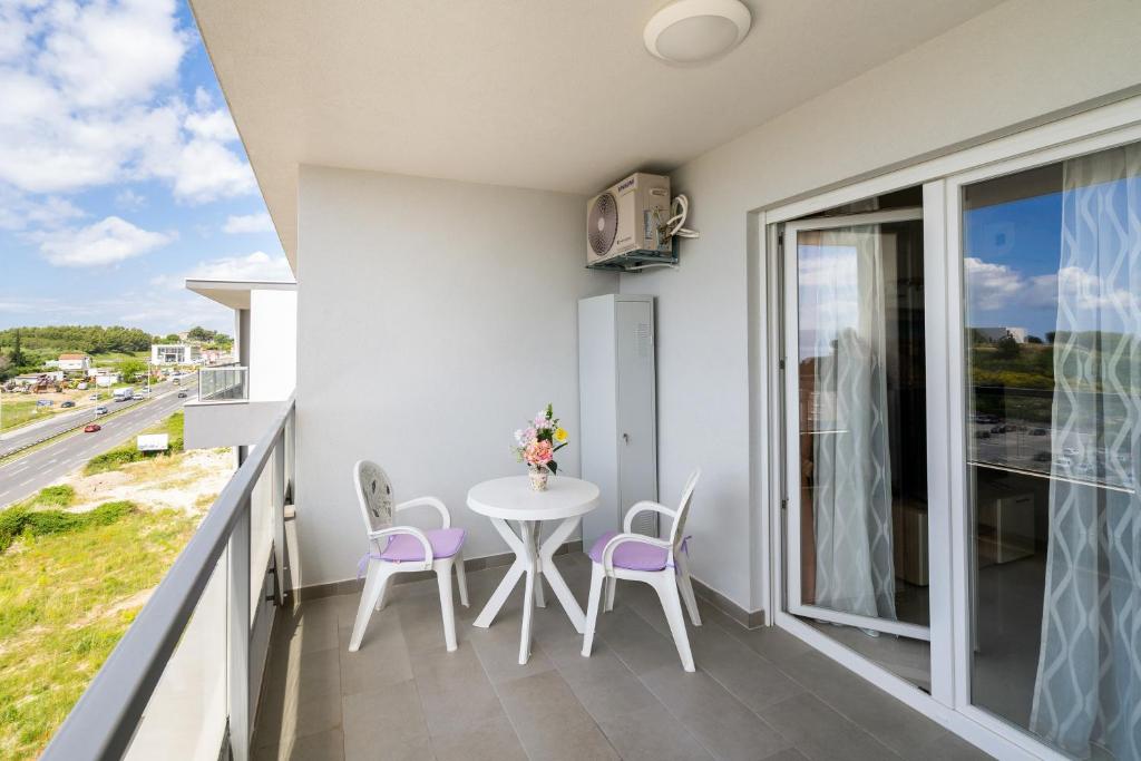 斯普利特A2 - modern apt with the terrace & sea view的设有一个配有白色桌椅的阳台,享有美景。