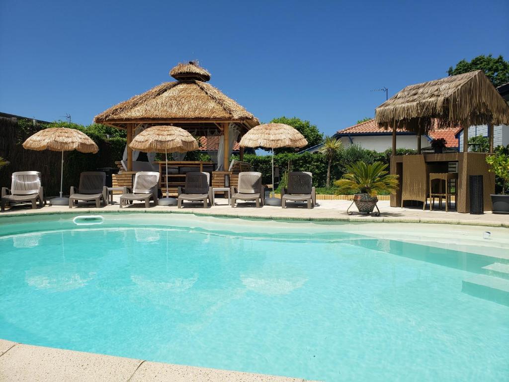塔尔诺斯Chalet Zure Ondoan - SPA et piscine chauffée的一个带椅子和遮阳伞的大型游泳池