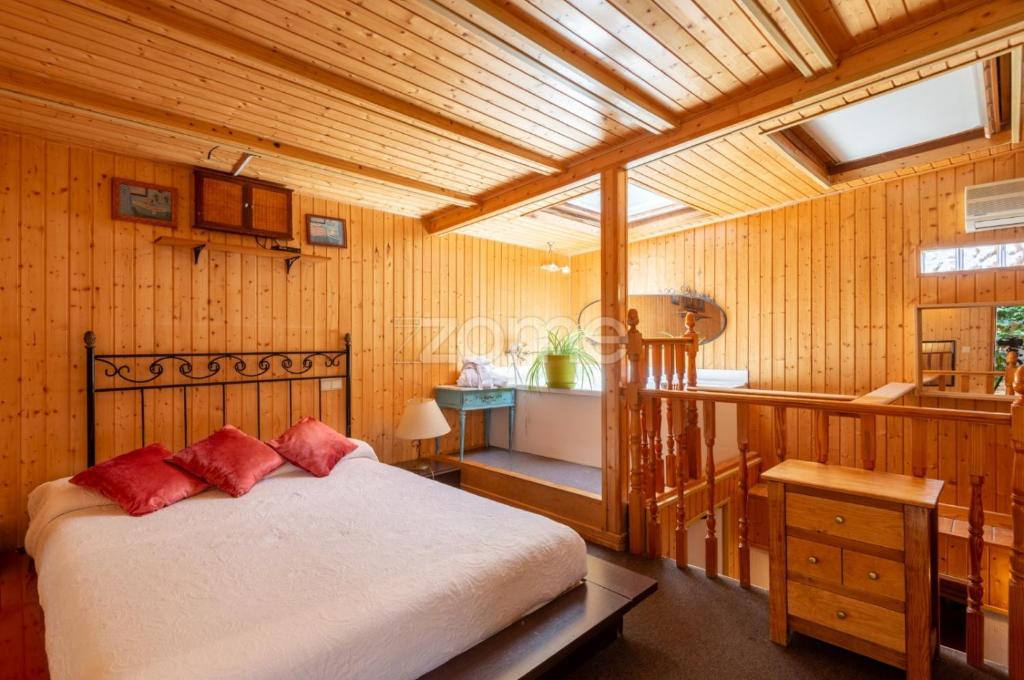 纳瓦尔卡内罗Hotel Rural Mansión的一间卧室配有一张床,浴室设有水槽