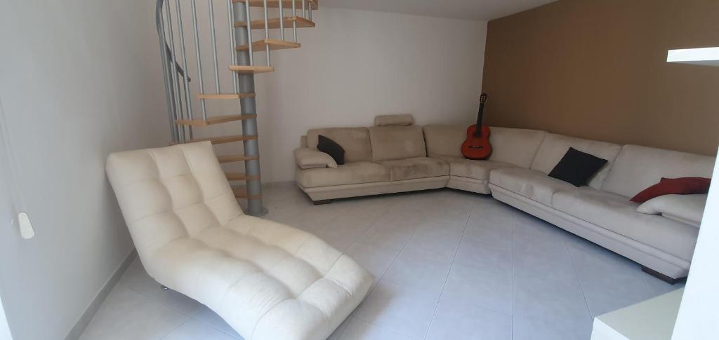 莱切La casa nel barocco的客厅配有2张白色沙发和吉他