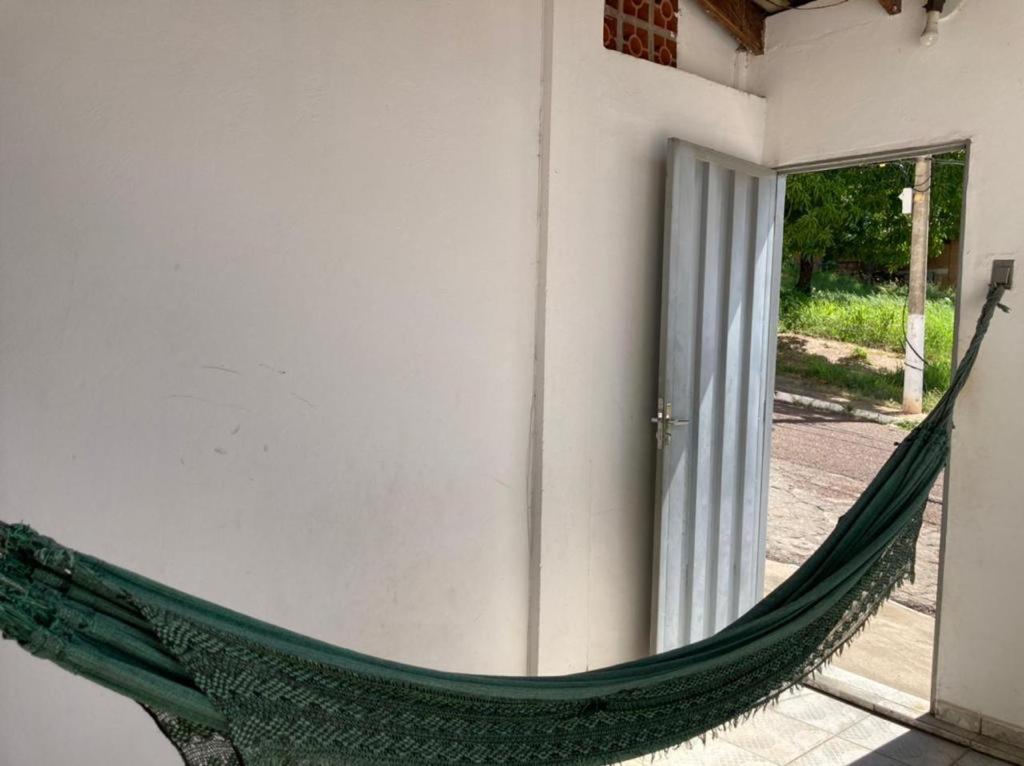 库亚巴Aluguel de loft mobiliado em Cuiabá的靠在建筑物上的绿色吊床
