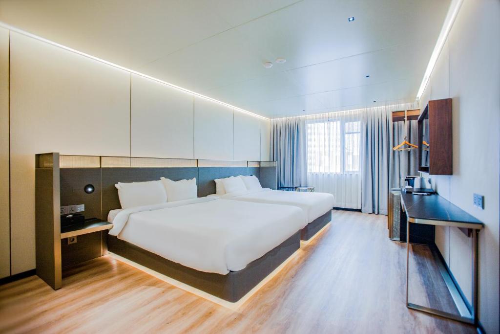 济州市济州琥珀酒店的一间大卧室,配有一张大床和一张书桌