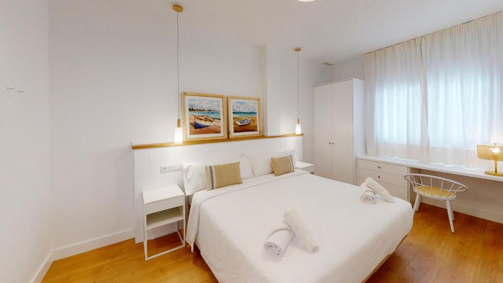 厄尔-汝姆披多Apartamentos La Casa El Palo的白色的卧室设有白色的床和窗户。