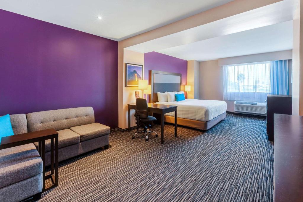 蒙特雷CHN Hotel Monterrey Aeropuerto, Trademark by Wyndham的酒店客房配有一张床、一张沙发和一张书桌。