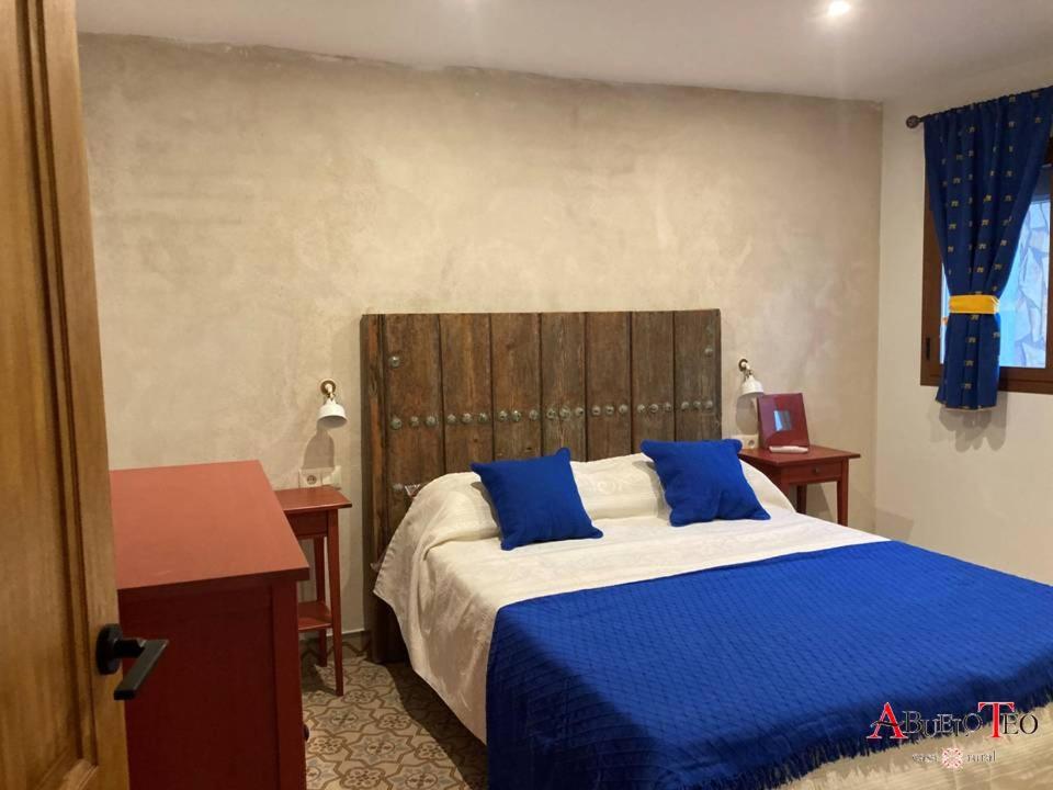 坎波德克里普塔纳Casa Rural Abuelo Teo的一间卧室配有一张带蓝色枕头的大床