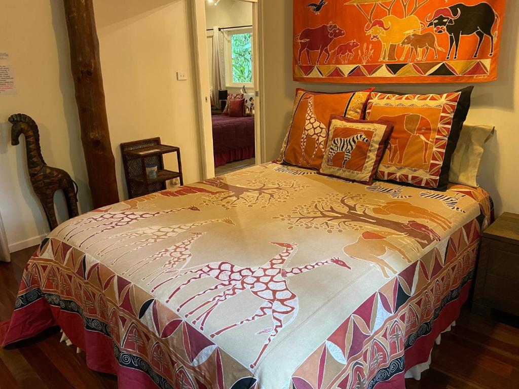 库兰达库兰达恩戈罗恩戈罗山林小屋的一间卧室配有一张带五颜六色棉被的床