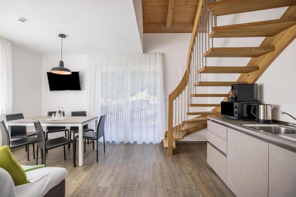 圣维吉利奥Apartment Set Residence Bun Ste的厨房以及带桌子和楼梯的用餐室。