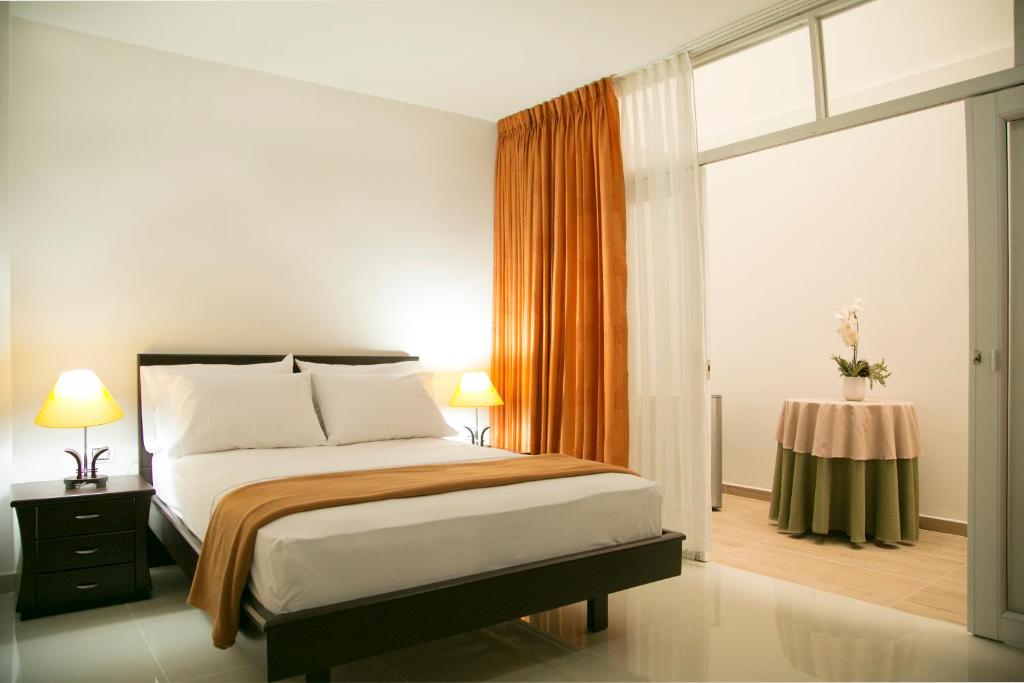 约帕尔Hotel Casimena的一间卧室设有一张床、一个窗口和一张桌子